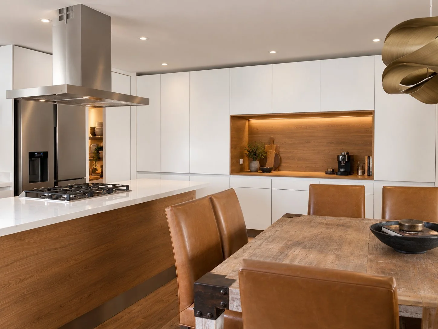 Cocina Lamartine, abierta y blanca, con isla y muebles de madera cálida